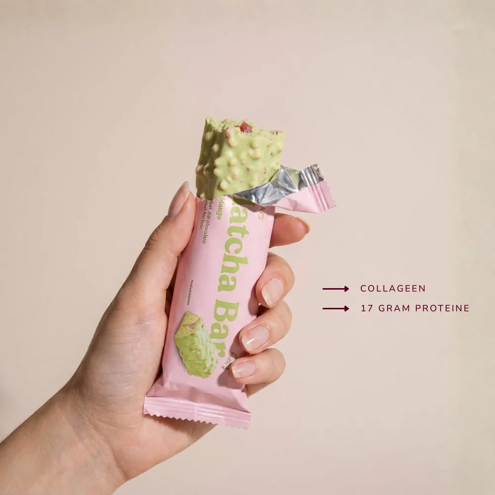 A hand holding a pistachio-green matcha bar