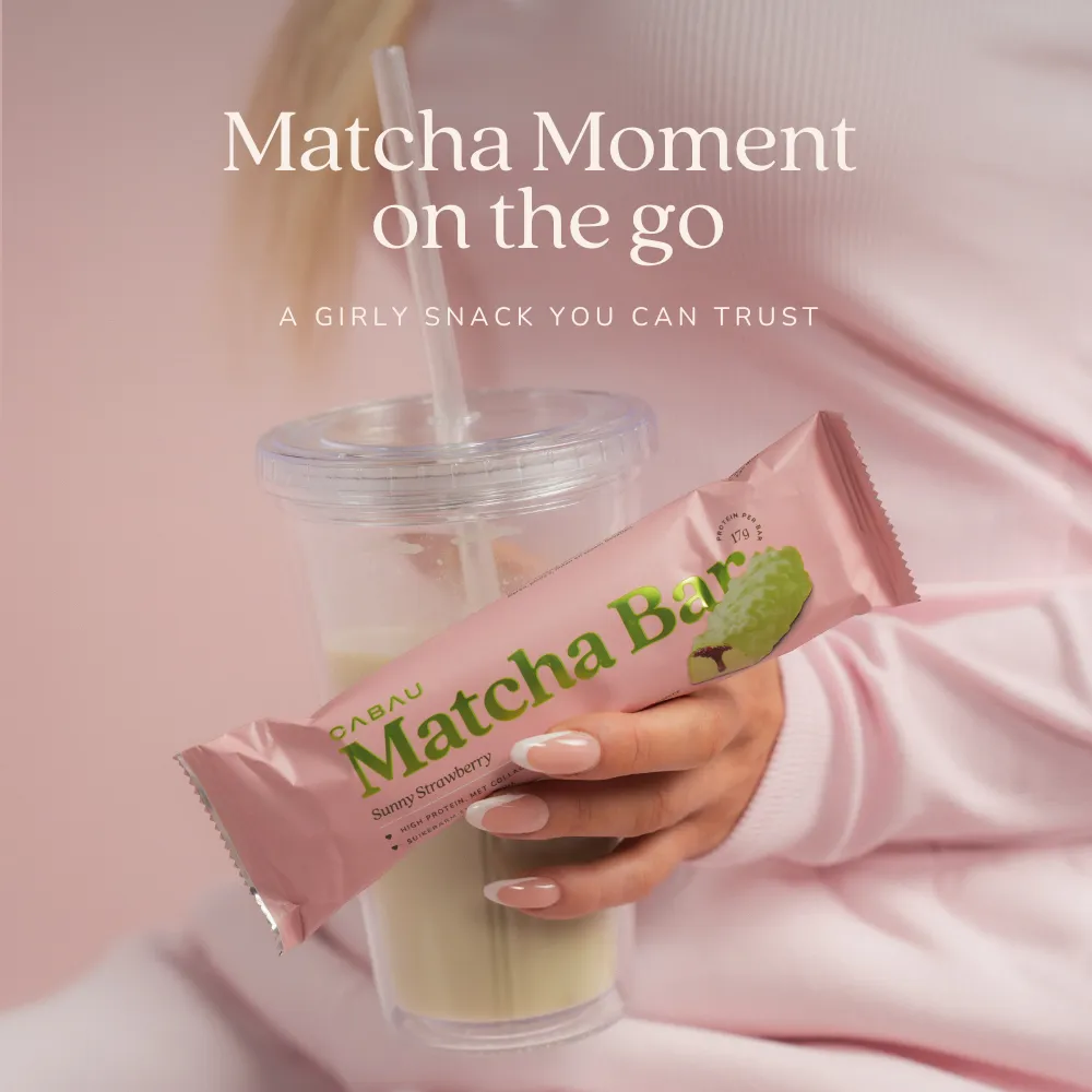 A matcha latte in a clear cup with a matcha bar