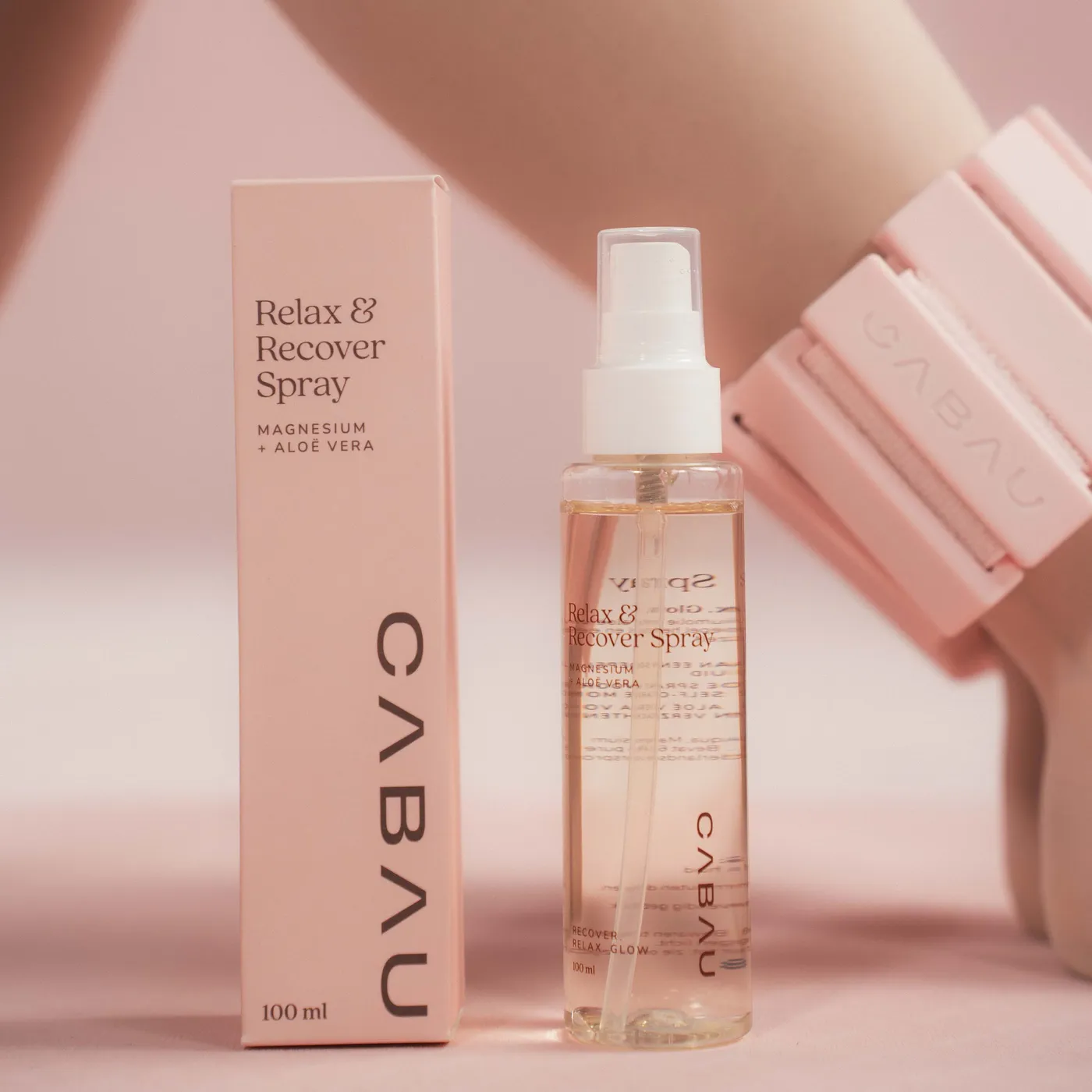 A pink Cabau spray bottle held against a pink wrist weight